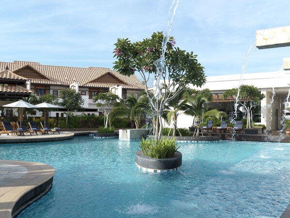 A pool area with lounge chairs and a fountain.