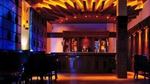 A bar area with wooden flooring and a bar counter. - Mastiff Grand Manali (Manali)