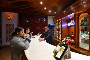 A bar area with a counter, bottles of wine, and a Pepsi refrigerator. - Mastiff Grand Manali (Manali)