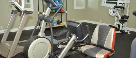 A gym with treadmills, an elliptical, and a weight machine.