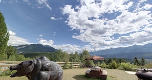 Enjoy a serene outdoor space with a bear sculpture, picnic table, and scenic views of the surrounding landscape.