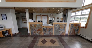 Welcome to our reception area, featuring a stylish desk and comfortable seating, with framed artwork adorning the walls.
