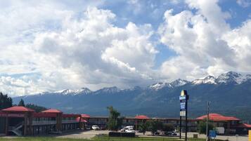 A hotel with a Days Inn sign, a pool, and a mountain backdrop.