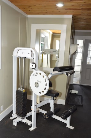Stay fit and active in our well-equipped gym featuring a weight bench, cable machine, and dumbbells.