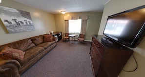 Relax in this inviting room with a leather sofa, flat-screen TV, and dining area.