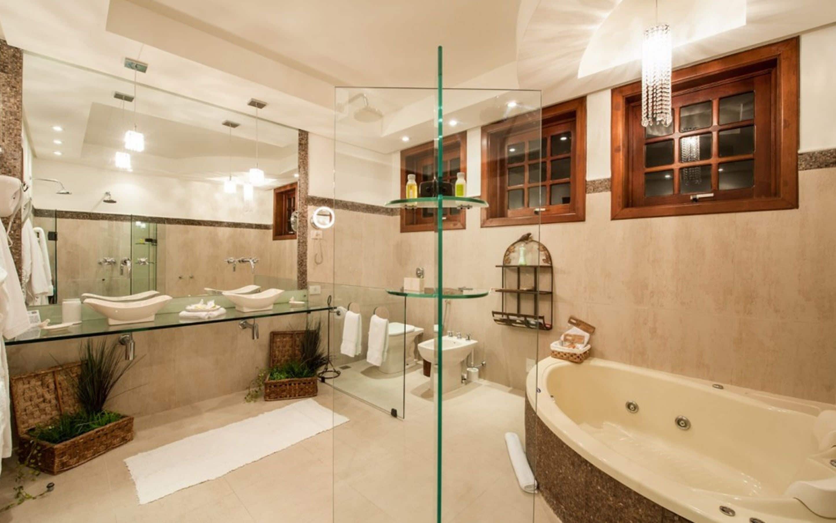 A modern bathroom with a glass-enclosed vanity, a freestanding bathtub, and a large mirror.