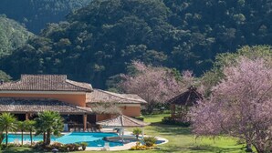 Un resort con piscina, un pabellón y un edificio con techo de tejas.