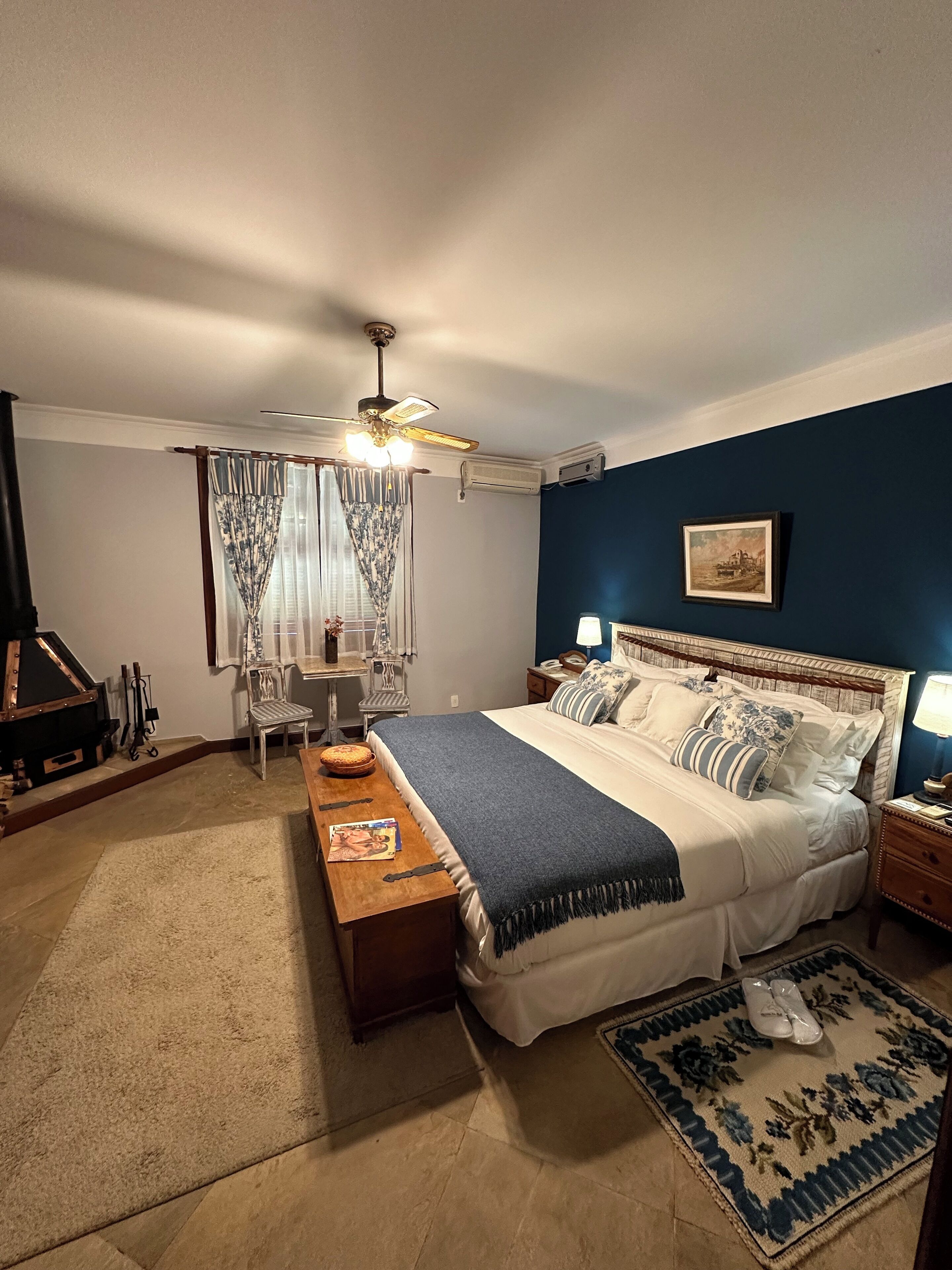 Ein Schlafzimmer mit Bett, Schreibtisch, Stuhl, Deckenventilator und Teppich.