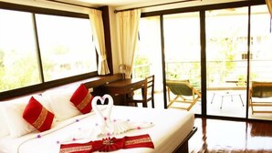 Quarto de hotel com cama grande, mesa de jantar e vista para o exterior.