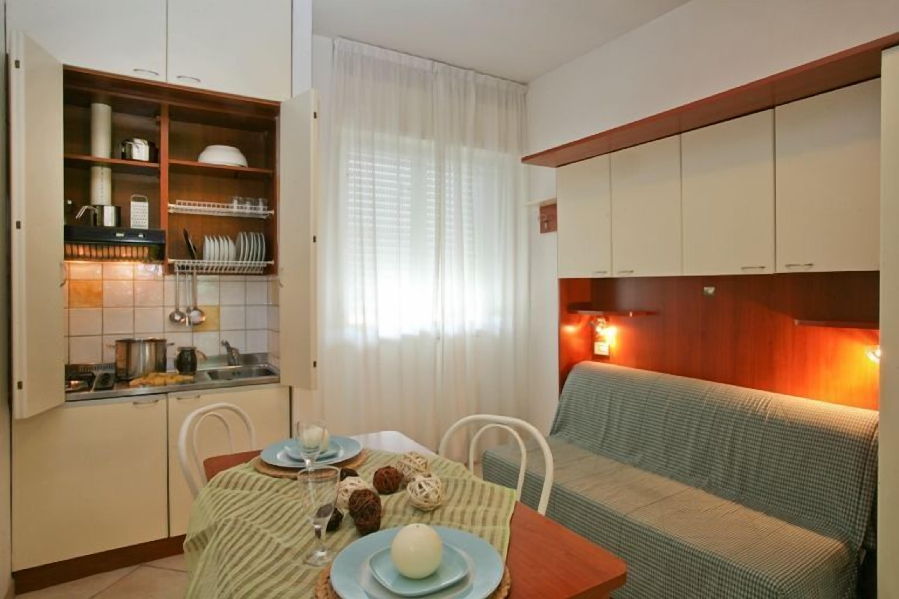 A compact living space with a kitchenette, dining area, and a sofa.