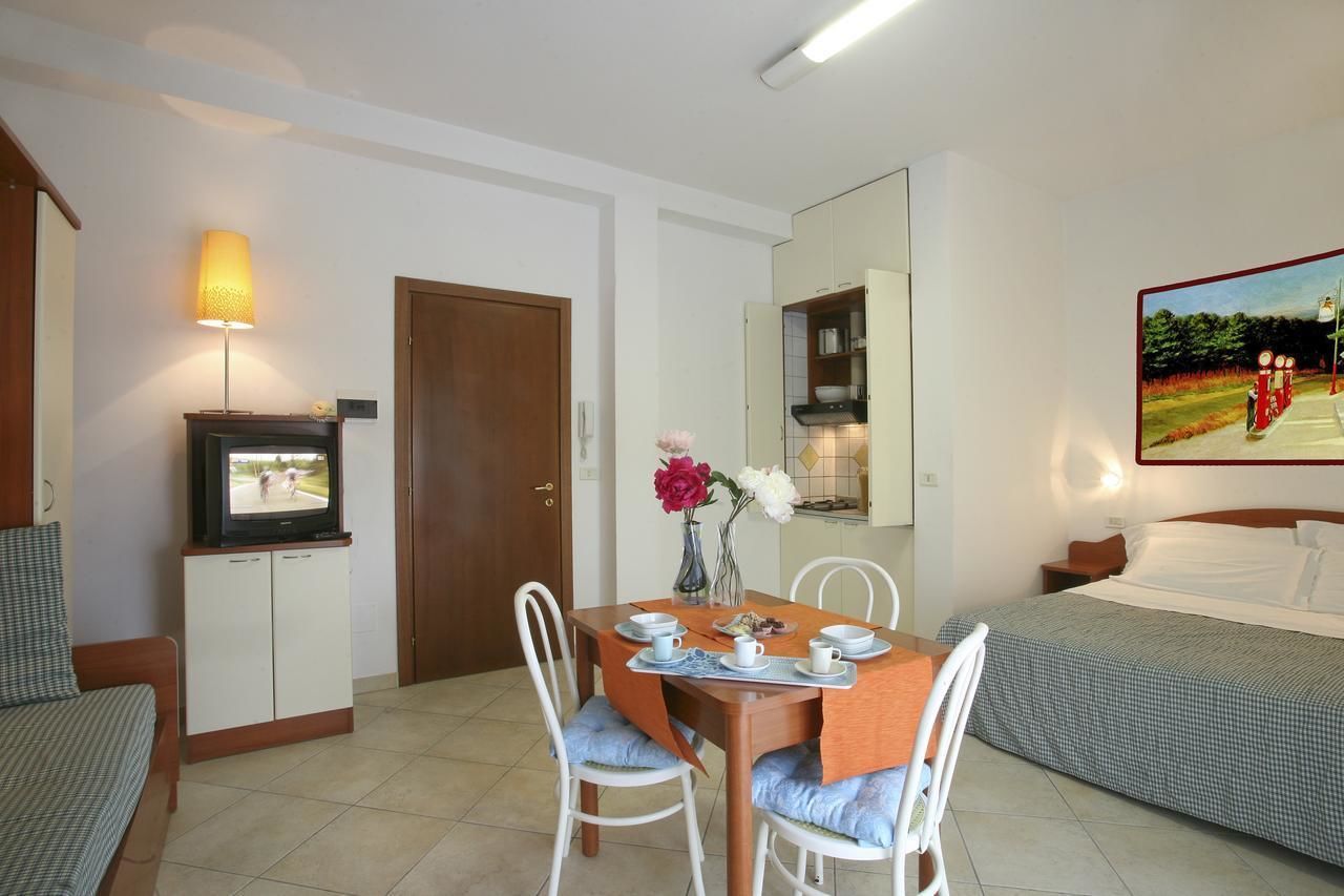 Ein Hotelzimmer mit Essbereich, Fernseher, einem Gemälde und einem Bett.