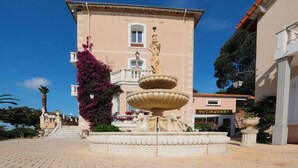 A building with a fountain, a staircase, and a restaurant sign.