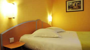 Een hotelkamer met een bed, nachtkastje en twee wandlampen.