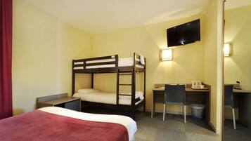 A hotel room with a bunk bed, a desk with a chair, a TV mounted on the wall, and a small trash bin.