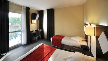 A hotel room with two beds, a desk, a chair, a TV, and a balcony with a railing.