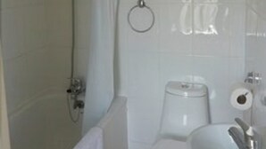 A bathroom with a shower, toilet, sink, and a towel rack. - Bennys B and B (London)