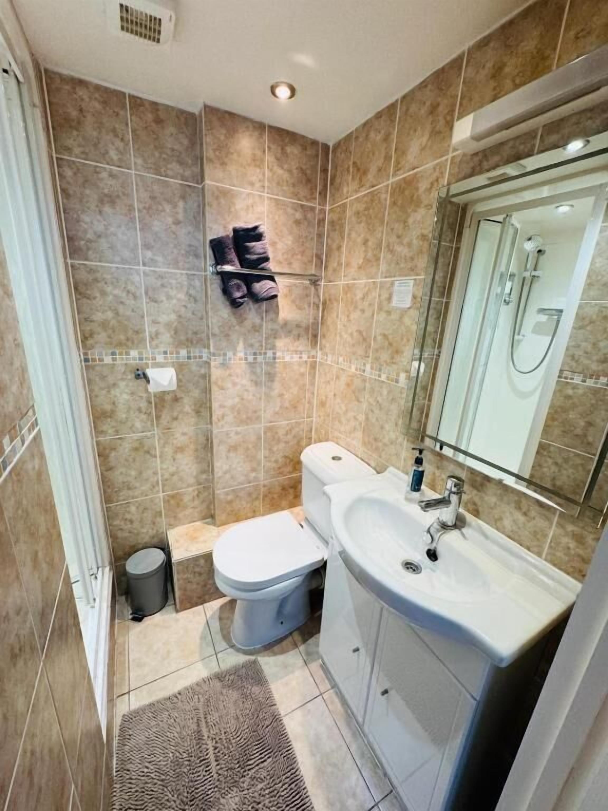 A bathroom with a toilet, sink, and shower.