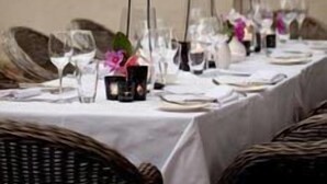 A table set for a meal with glasses, plates, and a small vase with flowers. - Kings Walden Garden Manor (Tzaneen)