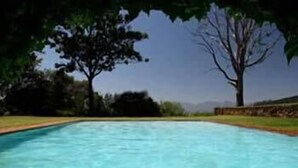 A rectangular swimming pool with clear blue water, surrounded by grass and trees. - Kings Walden Garden Manor (Tzaneen)