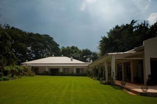 A large, single-story house with a well-maintained lawn and a covered porch.