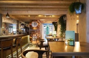 En mysig restaurang med trämöbler, en bardisk och en klocka på väggen.
