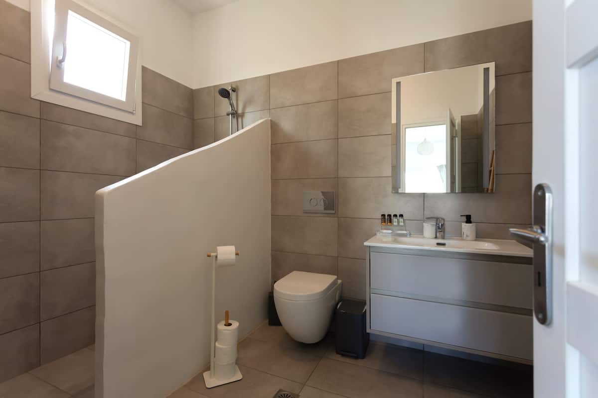 white suite partial view | bathroom | free toiletries, hair dryer, slippers, towels