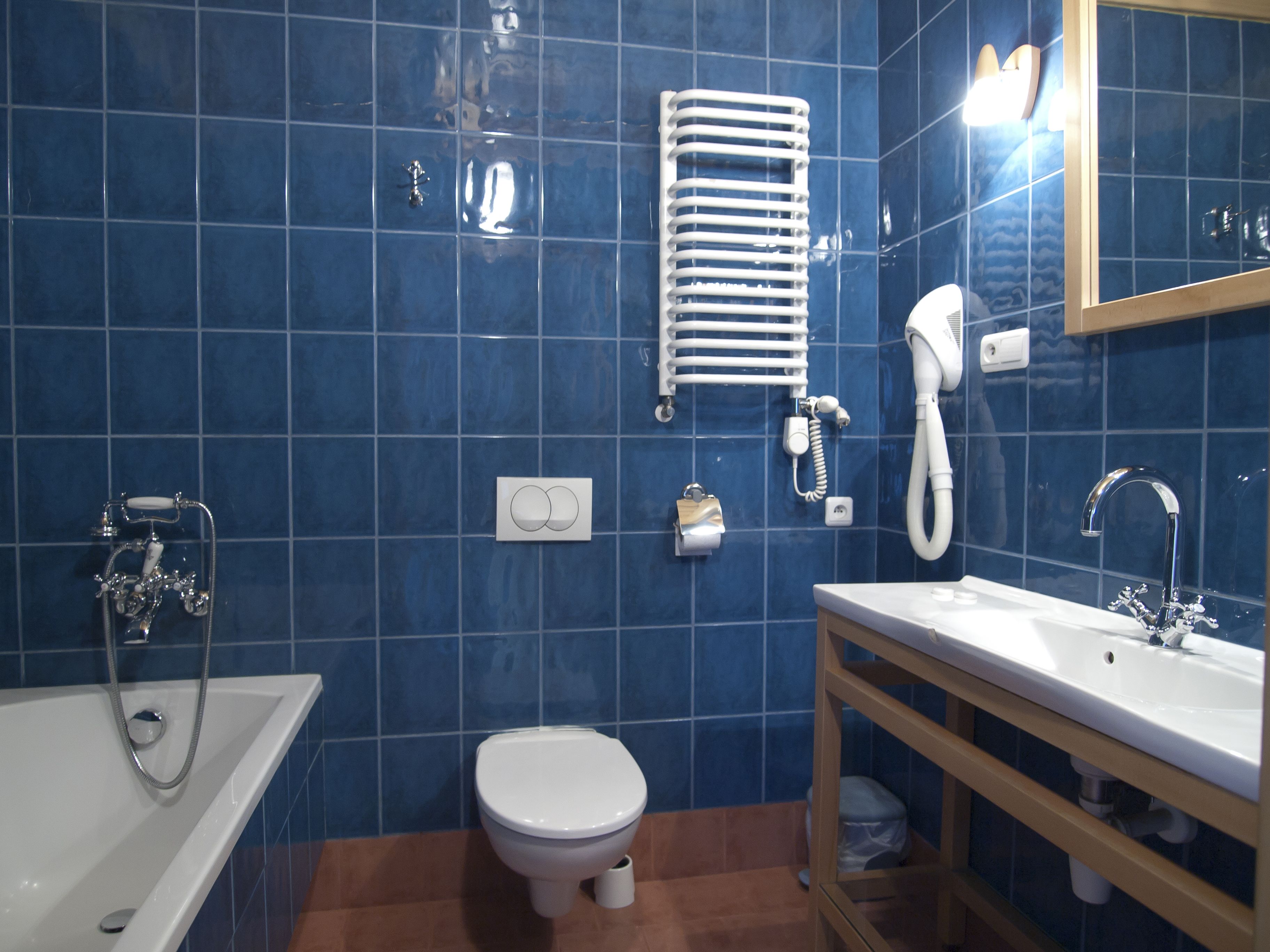 A bathroom with a bathtub, toilet, sink, and a towel rack.