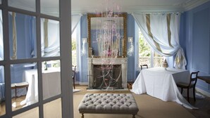 Una habitación con chimenea, una mesa y un banco.