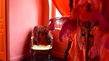 A room with a wooden floor, a chair, and a large feathered object.