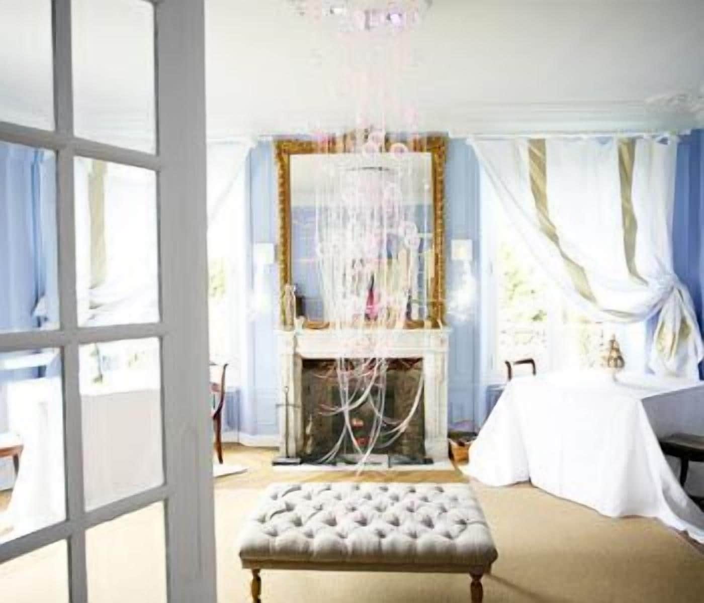 A room with a fireplace, a white table, and a tufted bench.