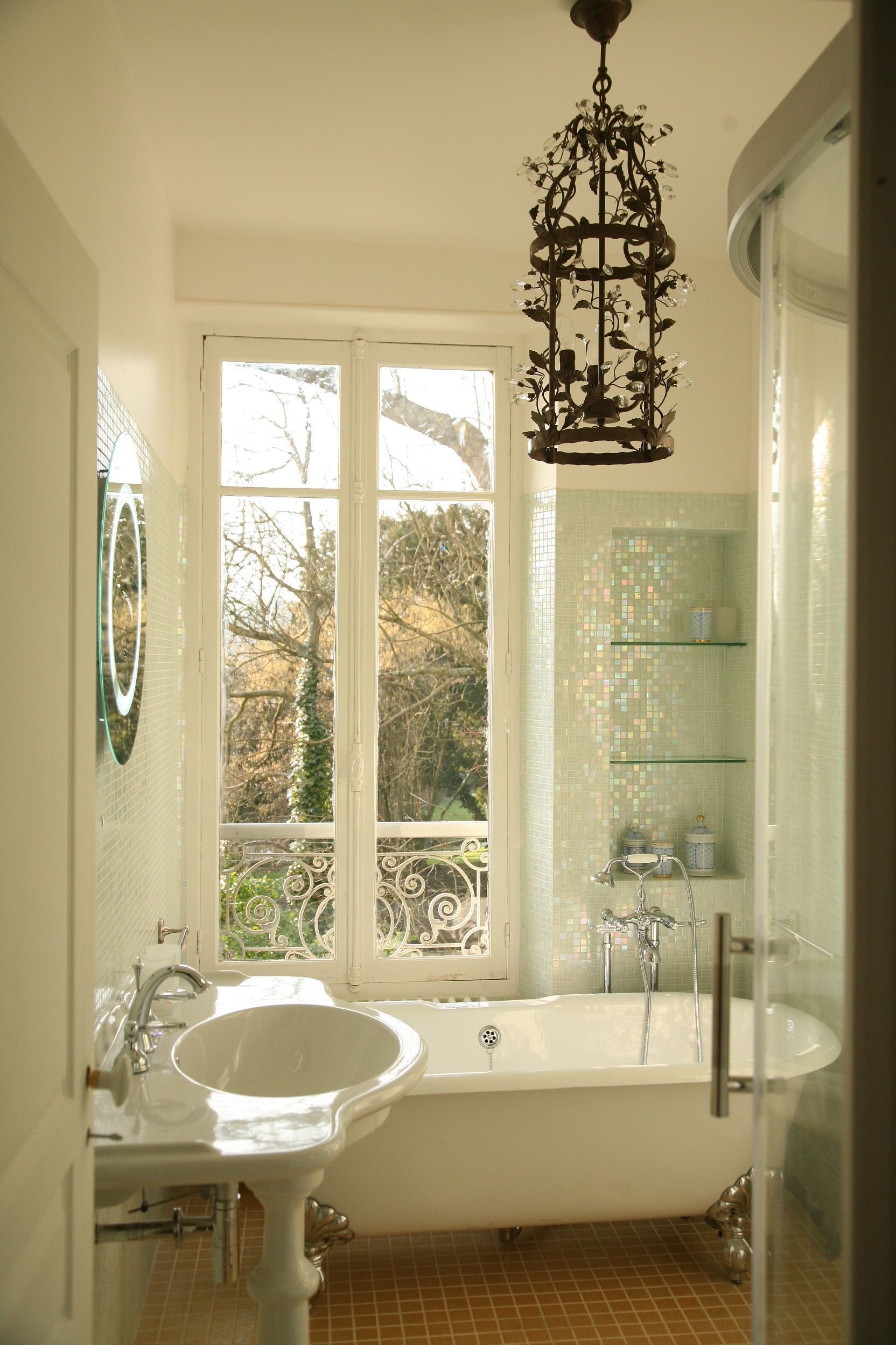 A bathroom with a freestanding bathtub, a sink, and a glass shower enclosure.