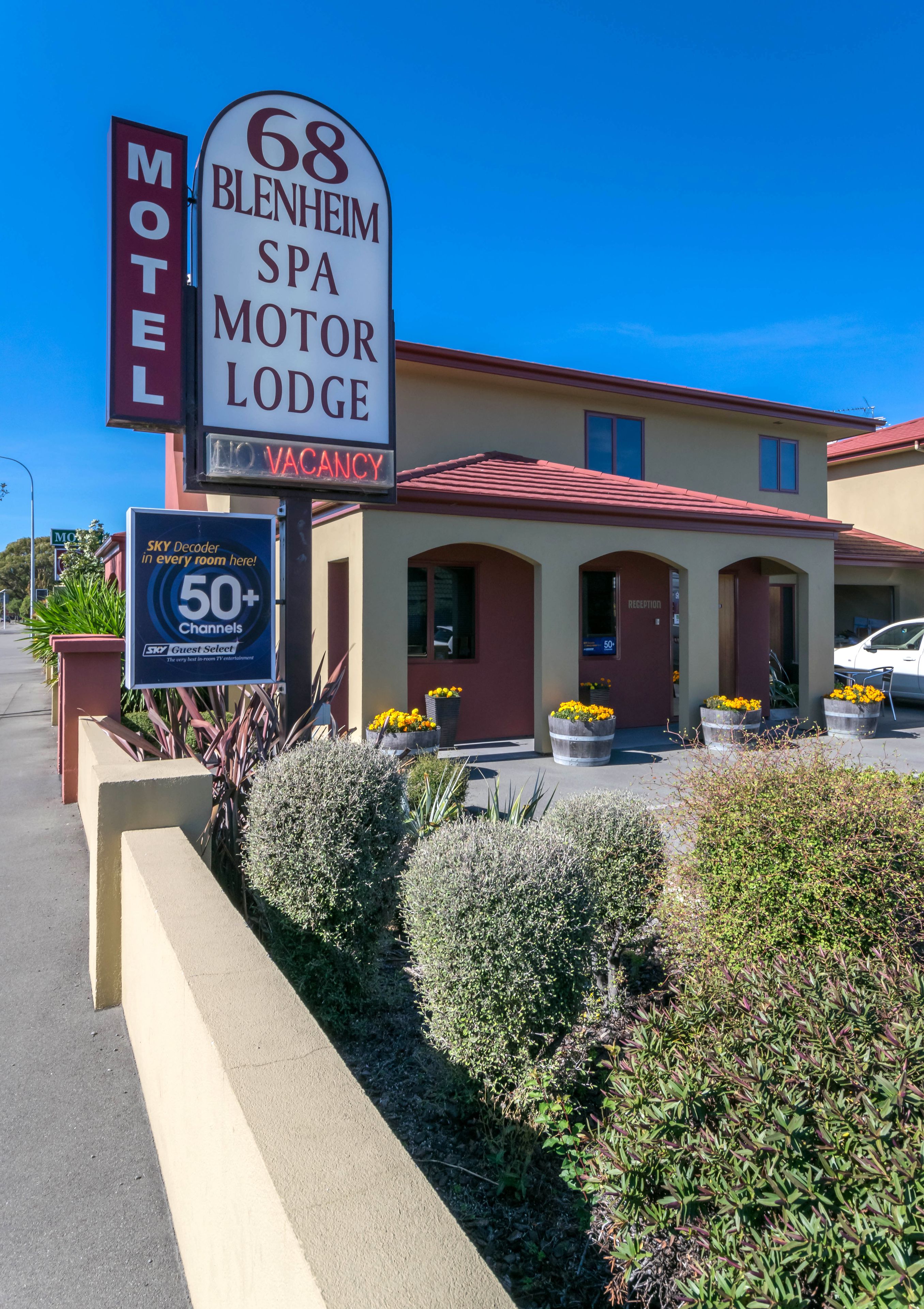Un motel avec une enseigne indiquant « Blenheim Spa Motor Lodge, 68 » et signalant qu’il y a des chambres disponibles.