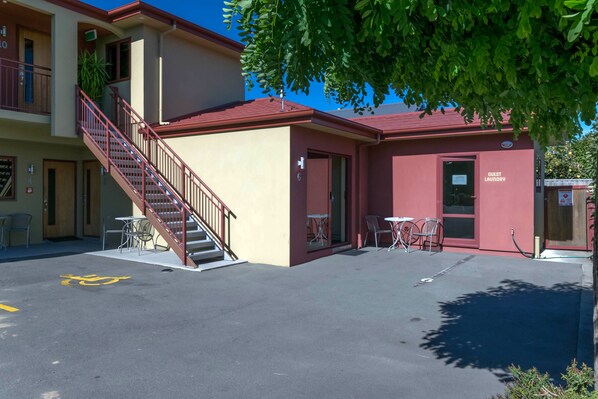 A building with a red roof, a guest laundry facility, and outdoor seating. - Blenheim Spa Motor Lodge (Blenheim)