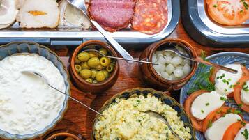 Diversos alimentos como embutidos, aceitunas y un tazón de queso fresco.