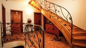 A wooden staircase with a curved design and metal railings, leading to an upper floor. - Villa Admiral (Gdynia)