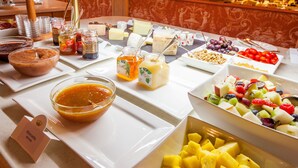 A buffet with various food items including fruits, cheeses, and condiments. - Park Hotel Principe (Collina d'Oro)