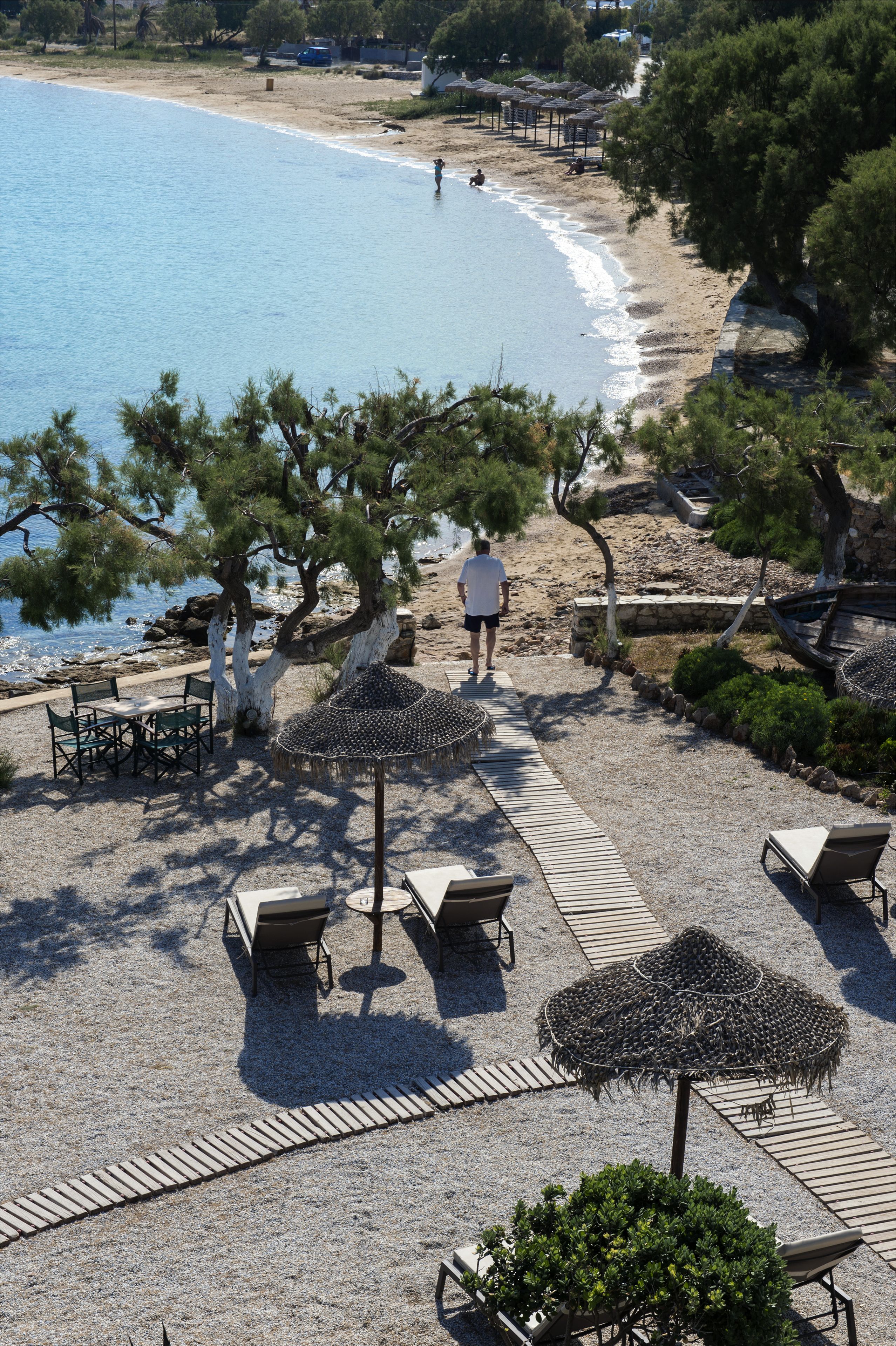 A beachside resort with outdoor seating, umbrellas, and a view of the sea.
