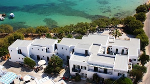 A coastal hotel with a pool, beach access, and clear waters. - Kalypso Hotel (Paros)