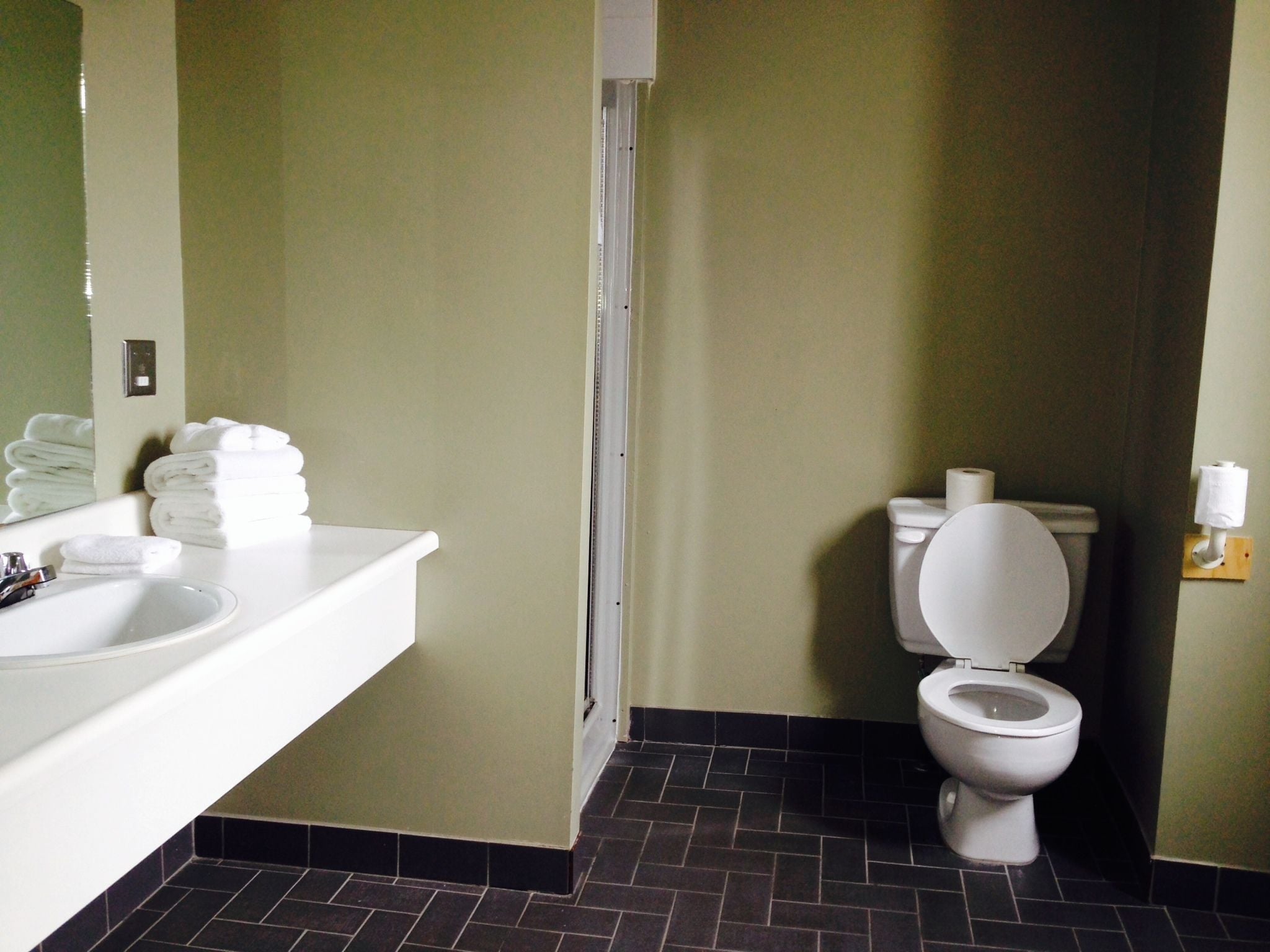 Een badkamer met een wit wastafel, toilet en spiegel.