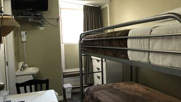 A bunk bed room with a television, a sink, and a window.