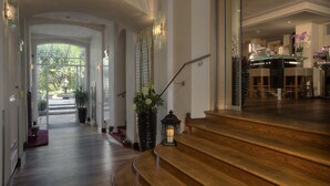 A grand staircase leading to a dining area with a view of the outdoors. - MAXIMILIAN MUNICH Apartments & Hotel  (Munich)