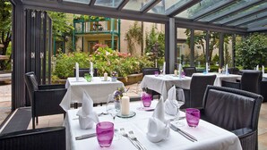 A restaurant with outdoor seating, white tablecloths, and purple glassware. - MAXIMILIAN MUNICH Apartments & Hotel  (Munich)