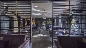 Un interior moderno con un espacio central abierto, rodeado de zonas de estar y un bar.