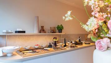 Ett modernt kök med en köksö i mitten, olika sorters matvaror och en vas med blommor.