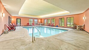 An indoor swimming pool with lounge chairs and tables, large windows, and a high ceiling. - Comfort Suites Gothenburg South (Gothenburg)