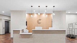 A reception area with a wooden accent wall, a large desk, and overhead lighting. - Comfort Suites Gothenburg South (Gothenburg)