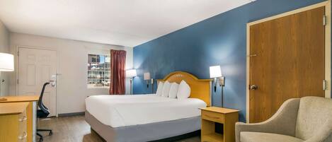 Une chambre d’hôtel équipée d’un lit, d’un bureau, d’une chaise et d’une armoire.