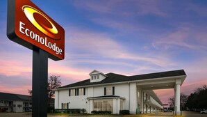 Un motel avec une grande enseigne indiquant « EconoLodge » et une station-service attenante au bâtiment.