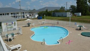 Una piscina al aire libre de temporada, sillones reclinables de piscina