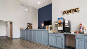 Un espace cuisine moderne équipé d’un coin café, d’une télévision et d’une enseigne indiquant « CAFÉ ».